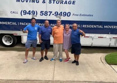 Five people standing in front of a Terry Moving & Storage truck, smiling and posing together.